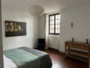 ein Schlafzimmer mit Bett, Schreibtisch und Fenster in der Unterkunft La maison du pont vieux - emplacement de parking gratuit - Proche Cité médiévale in Carcassonne