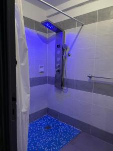 ein Bad mit einer Dusche mit blauem Licht in der Unterkunft La maison du pont vieux - emplacement de parking gratuit - Proche Cité médiévale in Carcassonne