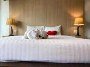 a white bed with two hearts and two lamps at A Plus Deluxe Hotel in Ko Lipe