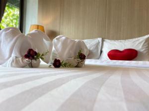 a bed with white pillows with a red heart on it at A Plus Deluxe Hotel in Ko Lipe
