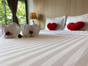 a bed with three pillows with hearts on it at A Plus Deluxe Hotel in Ko Lipe