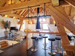 a room with a loft with a table and stools at Villa Savoie - luxe et sérénité- piscine et jacuzzi - vue panoramique sur le lac d Annecy in Veyrier-du-Lac