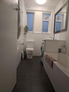Un baño con inodoro y lavadora. en Ground Floor Elwood village Apartment, en Melbourne