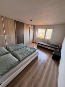 a bedroom with a large bed and wooden floors at Dom Udavské in Udavské