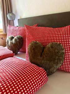 twee teddyberen zittend op een bed met rode kussens bij Apart Wiesa in Kappl