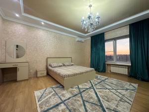 a bedroom with a bed and a chandelier at 3 комнатная ЖК Альтаир in Aktobe