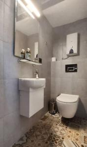 Un baño con inodoro, lavabo y espejo. en Urla Seaside House, en Ildir