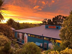 un edificio con una puesta de sol en el fondo en Global Village Travellers Lodge, en Greymouth