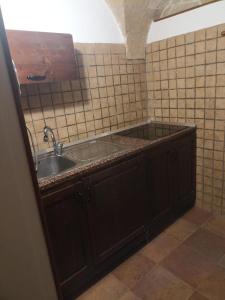 a kitchen with a sink and a tiled wall at Casa Vacanza De Flagilla in Brindisi +5 photos
