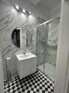 a bathroom with a sink and a shower with a mirror at Apartament OPAL2 Mickiewicza in Tarnowskie Góry +20 photos