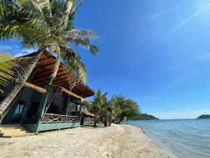 象岛Kai Bae Beach Resort Koh Chang的棕榈树和水滩上的度假村