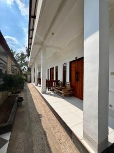 Un patio vacío de un edificio blanco con puertas de madera. en Bale sunrise, en Gili Trawangan