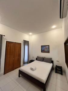 Un dormitorio con una cama y una puerta de madera. en Bale sunrise, en Gili Trawangan