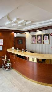 a lobby with a reception desk and portraits of people at صبا أحد للشقق المخدومة - Saba ohod Serviced Apartments in Al Madinah