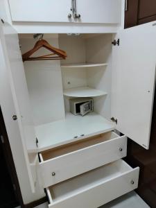 a white closet with white drawers and shelves at La grande Hotel & Residence in Angeles +12 photos