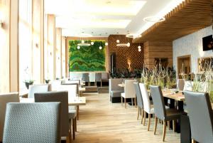 una sala da pranzo con tavoli e sedie bianche di Hotel Grand a Chlumec nad Cidlinou