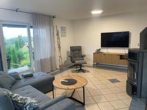 a living room with a couch and a tv at Ferienwohnung Wintersonne in Bad Mergentheim