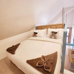 a large white bed with two teddy bears on it at Seaview Home Samet in Ko Samed