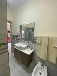 a bathroom with a sink and a toilet and a mirror at Albizia, casevacanza in Agropoli +49 photos