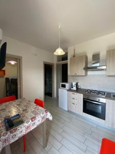 a kitchen with a table and a kitchen with a stove at Albizia, casevacanza in Agropoli