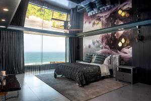 a bedroom with a bed and a large window at Flamenco@Colwyn in Sheffield Beach
