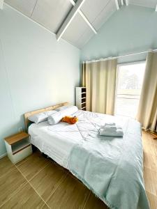 une chambre avec un grand lit avec un animal en peluche dessus dans l'établissement Mai Rut Beach Eco Resort and Camping, à Ban Nong Wiwat