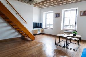 a living room with a staircase and a table and a television at HYPER CENTRE COSY DUPLEX dans les remparts in Boulogne-sur-Mer
