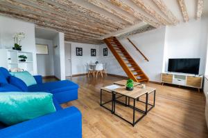 a living room with a blue couch and a table at HYPER CENTRE COSY DUPLEX dans les remparts in Boulogne-sur-Mer