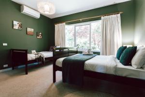 a green bedroom with two beds and a window at Rosella in Hepburn