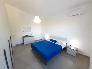 Un dormitorio con una cama azul en una habitación blanca. en Campofelice Holidays West Villa, en Campofelice di Roccella