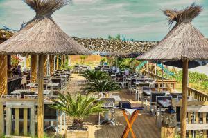 a restaurant with tables and chairs and umbrellas at Hotel & Restaurant San Pellegrino in Folelli