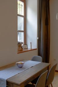 a dining room table with chairs and a window at Konak Apartment in Sarajevo