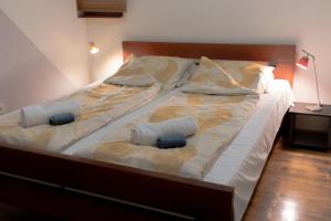 a bed with two pillows and a cat laying on it at Konak Apartment in Sarajevo