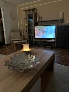 een woonkamer met een televisie en een tafel met een kaars bij Ferienwohnung Winterberg Centrum 2 mit privatem Ski Keller in Winterberg
