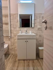 Un baño con un lavabo blanco y un espejo. en L'Ulivo Nascosto, en Martina Franca