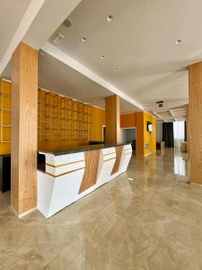 a lobby with yellow walls and a reception desk at Hotel Panorama & Spa Elbasan in Elbasan +70 photos
