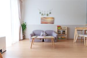un salon avec un canapé et une table dans l'établissement Habitacion Cottage Suzu, à Fujikawaguchiko