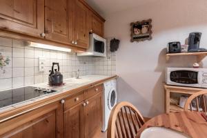 een keuken met een wasmachine en een magnetron bij Les Carlines in Les Contamines-Montjoie
