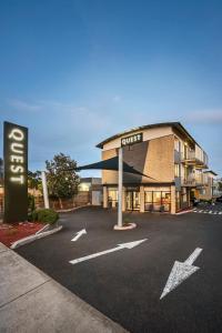 a building with a guest sign in a parking lot at Quest Frankston in Frankston