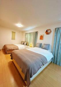 a hotel room with two beds and blue curtains at DeL'm 難波から徒歩圏内京都奈良universal studio 関西空港まで交通便利無料駐車場付き in Osaka