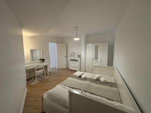 a white bedroom with a bed and a desk at La Tejita Paradise in La Tejita +9 photos