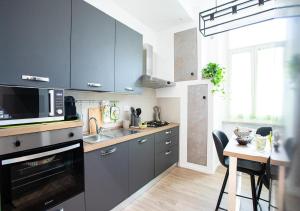 una cucina con mobili blu e un tavolo con un microonde di Casa Appleton a Foligno