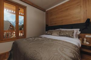 a bedroom with a large bed and a window at Goldhorn Chalet SKI IN&OUT in Kranjska Gora +70 photos