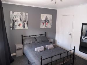 a bedroom with a bed with two pillows on it at The Tipsy Coo in Bridge of Earn