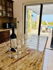 a bottle of wine sitting on a counter with wine glasses at Villa Amandine in Peyia