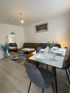 a living room with a white table and chairs at Cosy Modern Flat with garden in Longbridge