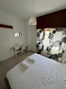 Un dormitorio con una gran cama blanca y un escritorio. en Milky, en Limassol 8 fotos más