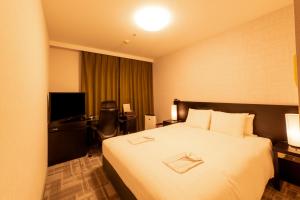 a hotel room with a bed and a desk at Richmond Hotel Kagoshima Tenmonkan in Kagoshima +87 photos
