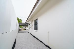 eine Gasse zwischen zwei weißen Gebäuden in der Unterkunft ME House Banchang in Ban Chang