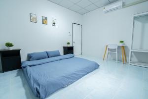 ein Schlafzimmer mit einem blauen Bett in einem weißen Zimmer in der Unterkunft ME House Banchang in Ban Chang